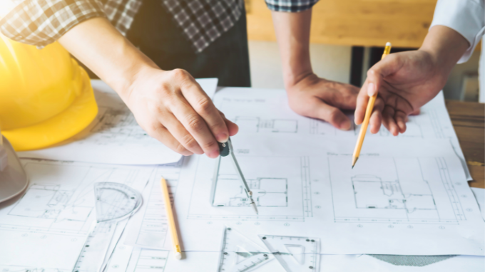 Workers overseeing a blueprint of a project.